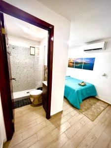 埃尔蒙特Mayara Hostal的客房设有带一张床和卫生间的浴室。