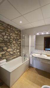 桑提亚纳德玛卡松萨洛杉矶骑士酒店的浴室配有石墙、浴缸和水槽。