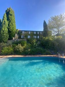 CanensBastide de 500m2 - Piscine, vue sur les Pyrénées的建筑物前水面上的岛屿