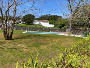 英雄港Casa de Campo Franco da Serra的一个带游泳池和石墙的庭院
