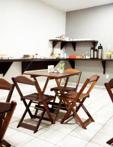 大瓦尔泽亚Hotel Los Angeles Aeroporto的厨房里配有一张木桌和椅子