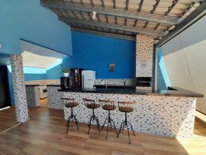里贝朗普雷托Espaço céu Azul的厨房设有带凳子和蓝色墙壁的酒吧