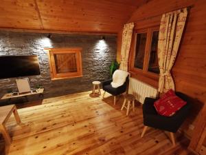拉布雷斯The dream catcher -Spa- panoramic sauna- 2 MINUTES FROM THE SLOPES的客厅铺有木地板,配有电视和椅子