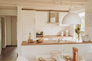 诺德霍恩ViLLA WASSERSTADT的厨房配有白色橱柜和水槽