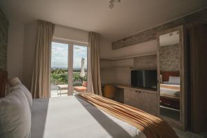 AgreloChozos Resort的酒店的客房 - 带一张床、一台电视和一个阳台
