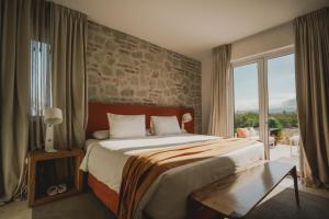 AgreloChozos Resort的一间卧室设有一张带石墙的大床