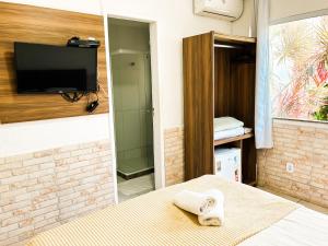 卡波布里奥IBELLO BEACH Pousada的一间设有床铺和墙上电视的房间