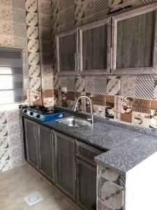 Aş ŞāfīWalaa Chalet的一个带木制橱柜和水槽的厨房
