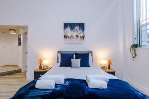 博尔顿Old Bank Studio Apartments的一间卧室配有一张大床,提供蓝色的床单和枕头