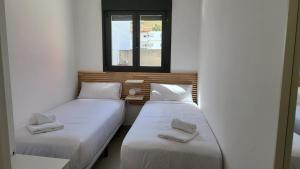 塞维利亚RentalSevilla La Salle的带窗户的客房内设有两张单人床。
