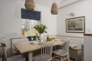 Saint MawganLobbs Cottage, St Mawgan的厨房以及带木桌和椅子的用餐室。
