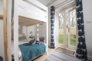Saint MawganLobbs Cottage, St Mawgan的一间卧室配有蓝色和白色窗帘的床