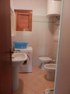 普林希匹纳马尔Il Gamberetto的浴室配有卫生间、盥洗盆和洗衣机。