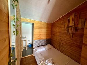 巴尔Raw KokoMar PosadaNativa的小房间,木墙里设有一张床