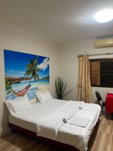 Ban Bo Sai KlangBatikseafood Airport & Room的卧室配有一张床,海滩画
