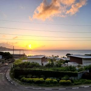 圣乔治Silver View Apartments的海上的日落,房屋和道路