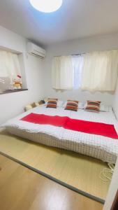 名古屋雲波館的一张大床,位于一个红色毯子的房间