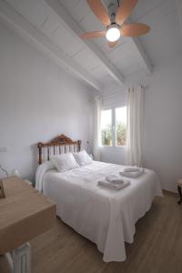 卡拉布兰卡KASSIOPEA的白色卧室配有床和吊扇