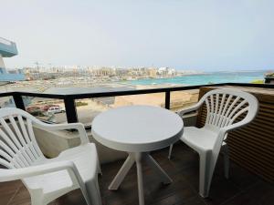 纳克萨R2 Salina Seaview Retreat的海滩阳台的白色桌椅