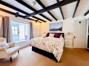 波尔佩罗The Cottage Bed & Breakfast的一间卧室配有一张床和一把椅子