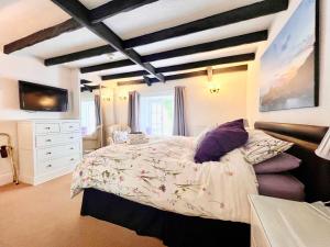波尔佩罗The Cottage Bed & Breakfast的一间卧室配有一张大床和一个白色梳妆台