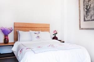 瓦哈卡市Hospedaje Donaji的卧室配有带鲜花的白色床