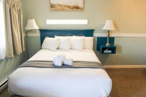 汉普顿The Janmere Motel的一间卧室配有一张大床和两条毛巾