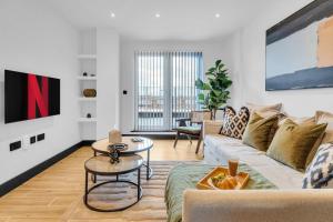 芬奇利homely- North London Penthouse Apartment Finchley的客厅配有沙发和桌子