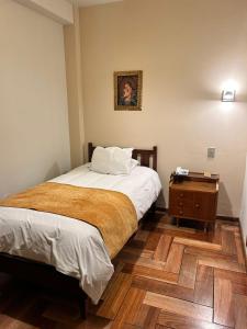 库斯科埃尔沃瑞精品酒店的一间小卧室,配有床和床头柜