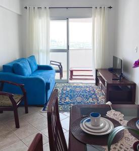 圣若泽杜斯坎普斯Pérola do Aquarius III的客厅配有蓝色的沙发和桌子