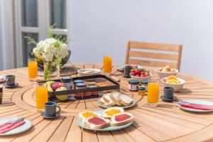 希俄斯Giustiniani Apartments的一张桌子,上面放着早餐食品和橙汁