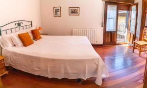 拉阿贝尔卡Casa del tablao的卧室配有带橙色枕头的大型白色床
