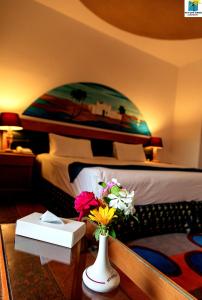 阿布辛贝塞提阿布辛贝湖度假酒店的一间卧室,配有一张带花瓶的桌子