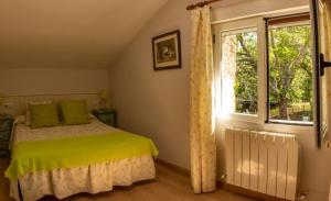 拉阿贝尔卡卡斯塔胡特乡村民宿的一间卧室配有一张带绿色枕头的床和一扇窗户