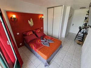 莱特鲁瓦西莱Sweet Crépuscule - Studio avec Vue Mer Imprenable & Piscine的一间卧室配有一张红色床头板的床