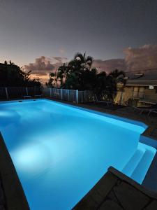 莱特鲁瓦西莱Sweet Crépuscule - Studio avec Vue Mer Imprenable & Piscine的蓝色照明的大型游泳池