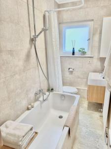 柏林2Room Apartment in Best Place的带浴缸、水槽和窗户的浴室
