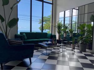 巴统Cabo Verde Boutique Hotel的客厅配有绿色沙发和盆栽植物