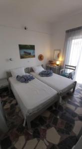 毕达哥利翁Alkisti's seaside apartments的带窗户的客房内设有两张单人床。