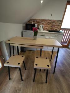 Glamping APARTMA NA KOZOLCU的厨房里设有一张带两个长凳的大木桌