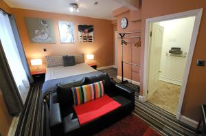 诺丁汉城中心罗宾7号酒店的一间卧室配有一张床、一张沙发和一把椅子
