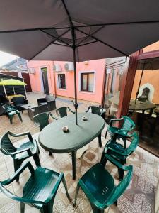 奥拉迪亚Central Hostel Partener的天井配有桌椅和遮阳伞
