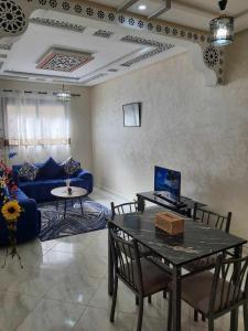 梅克内斯Appartement Dar Meknès的客厅配有桌子和蓝色沙发