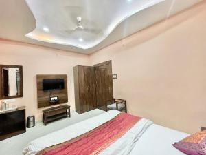 瓦拉纳西HOTEL NEEL GAGAN ! VARANASI fully-Air-Conditioned hotel at prime location, near Kashi Vishwanath Temple, and Ganga ghat的一间卧室配有一张床和一台平面电视