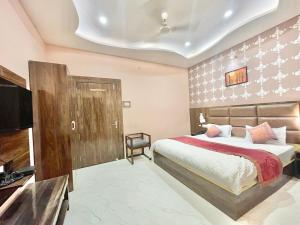 瓦拉纳西HOTEL NEEL GAGAN ! VARANASI fully-Air-Conditioned hotel at prime location, near Kashi Vishwanath Temple, and Ganga ghat的一间卧室配有一张床和一台平面电视