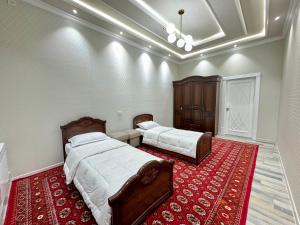 撒马尔罕Samarkand luxury apartament #8的一间带两张床的卧室和红色地毯