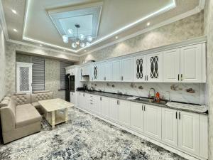撒马尔罕Samarkand luxury apartament #8的厨房配有白色橱柜和桌子