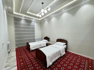撒马尔罕Samarkand luxury apartament #8的红地毯间内的两张床