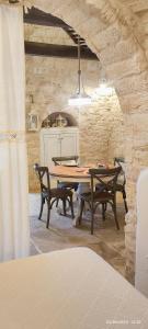 阿尔贝罗贝洛Trullo del Vescovo的一间带桌子和两把椅子的用餐室