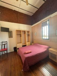 布宜诺斯艾利斯LGY G A Y Bed & Breakfast ONLY MEN的卧室配有粉红色的床和窗户。